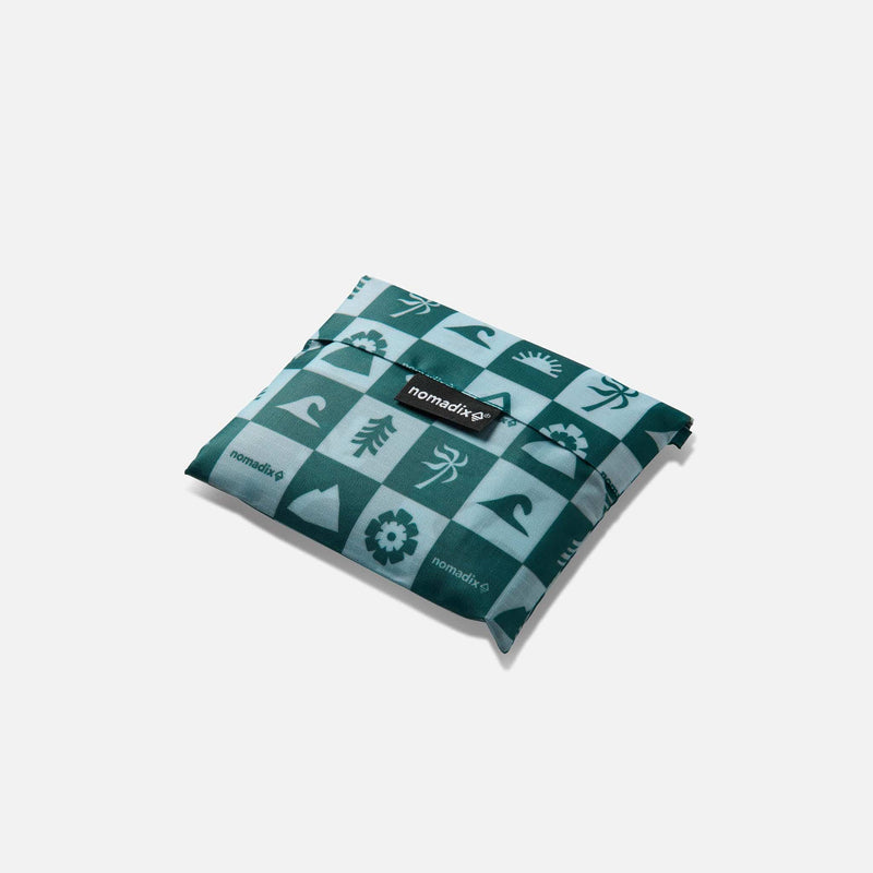 Load image into Gallery viewer, Folded teal fabric with pattern and 'nomadix' branding on a white background
