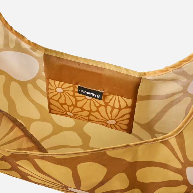 Load image into Gallery viewer, Floral-patterned bag with a visible brand label on a white background

