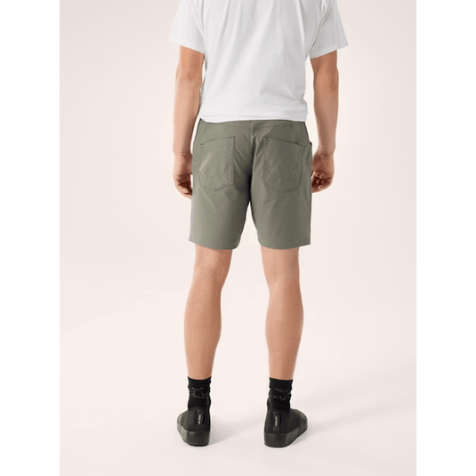 Person wearing olive green shorts on a white background